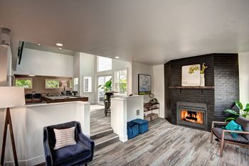 A living room with a fireplace and a kitchen